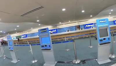 Alamo car rental counter with empty kiosks in airport terminal