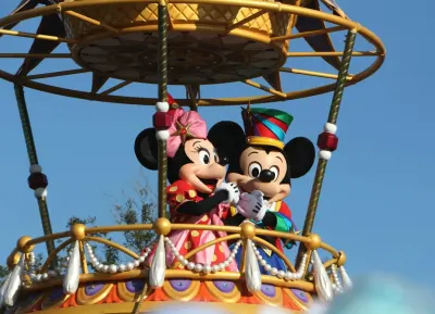 Mickey and Minnie Mouse in colorful parade float at Disney theme park