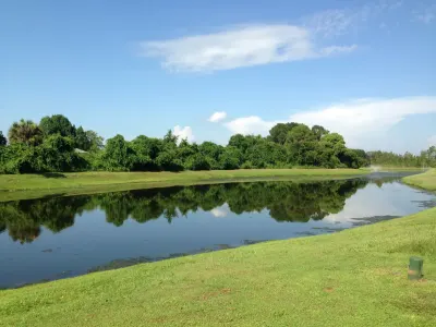 Calm waterway with tree-lined banks and manicured grass in Florida landscape