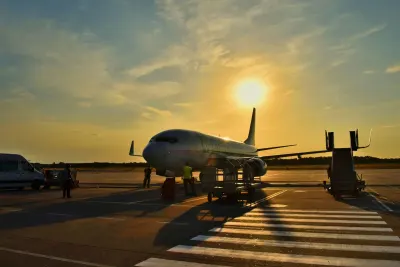 Commercial aircraft parked at airport terminal during golden hour sunset