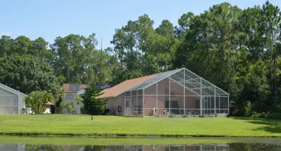 Waterfront Florida home with screened lanai and manicured lawn