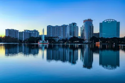 Lake Eustis skyline at sunrise with downtown Orlando high-rises and fountain reflection