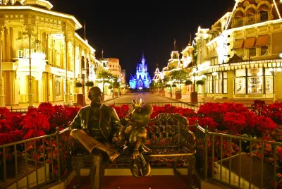 # Alt text:

Cinderella Castle illuminated at night with Main Street USA lined with golden buildings and red poinsettias