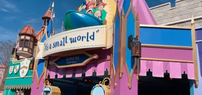 It's a Small World" attraction exterior with colorful castle facade and signage