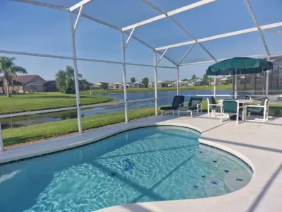 Screened-in residential pool overlooking canal and neighborhood homes in Florida