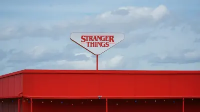 Stranger Things sign on red building against cloudy sky